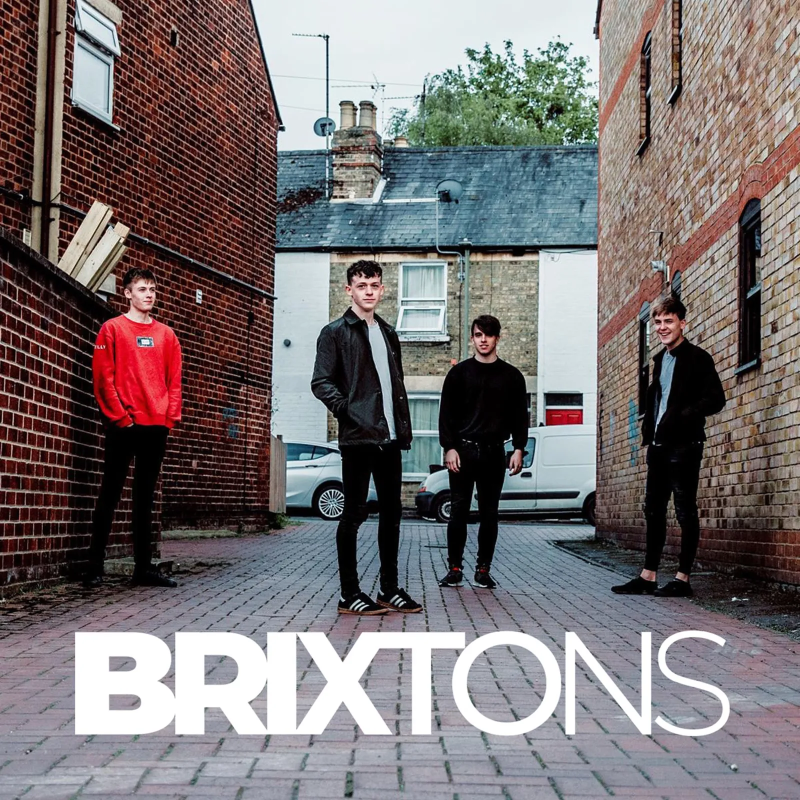 band members in alleyway with brixtons logo